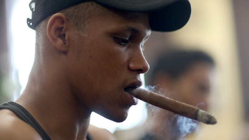 A worker smokes a cigar while making them in a cigar factory during the week-long International Habano Cigar Festival on February 26, 2015 in Havana, Cuba.