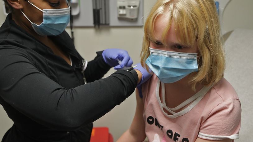Lily True, 9, gets her COVID-19 vaccine shot at the Rocking Horse Center in November. BILL LACKEY/STAFF
