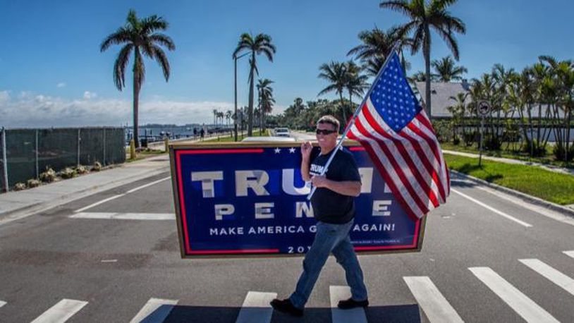 West Palm Beach resident Mike Sims carries signs to the intersection of Southern Blvd. and Flagler Dr. to wait for President Donald Trump's motorcade to pass by on the the way to Mar-A-Lago December 31, 2017. Sims and 15 other supporters came out to wave at the President almost every day during his Christmas vacation in Palm Beach, and on December 30 the President sent vans to pick them up and bring them to Mar-A-Lago for a visit. (Photo: Damon Higgins / The Palm Beach Post)
