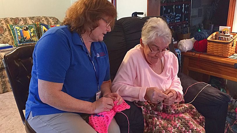 Comfort Keepers employee Beth Bowling (left) helps Kitty Parrett with help around her home. Comfort Keepers is celebrating 20 years in business. JEFF GUERINI/STAFF