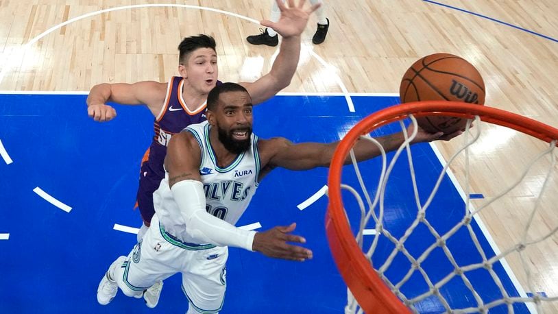 Minnesota Timberwolves guard Mike Conley, front, shoots as Phoenix Suns guard Grayson Allen defends during the second half of Game 2 of an NBA basketball first-round playoff series Tuesday, April 23, 2024, in Minneapolis. (AP Photo/Abbie Parr)