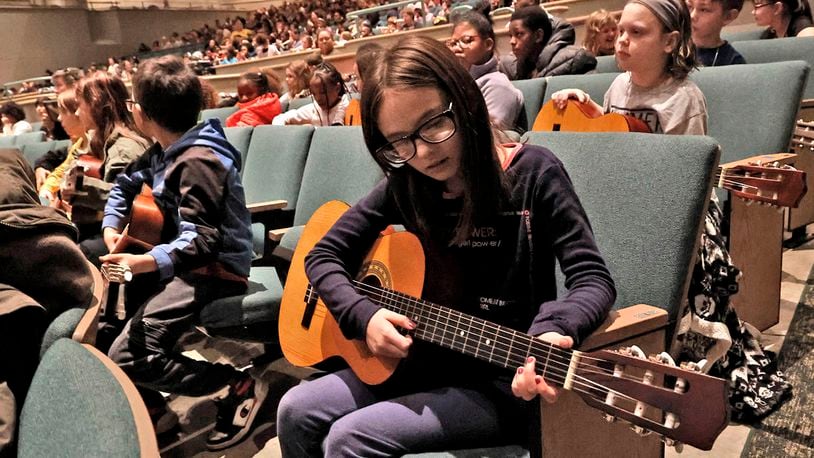 Emma Nehal follows along with the Springfield Symphony Orchestra on a guitar Thursday, Feb. 23, 2023 during the Link Up: The Orchestra Swings music program for students in grades 3-5 in Kuss Auditorium. Most student's brought their recorders to play along with the orchestra but kids in Jim Townsend's music class at Kenwood Elementary brought their guitars. BILL LACKEY/STAFF