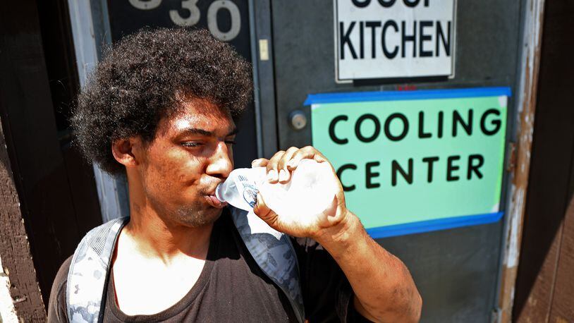 Brandon Clifford chugs a bottle of water he got in the Cooling Center at the Springfield Soup Kitchen Tuesday. As temperatures rose above 90 degrees the Soup Kitchen opened as a cooling center where people can come and get out of the heat and get some water. BILL LACKEY/STAFF