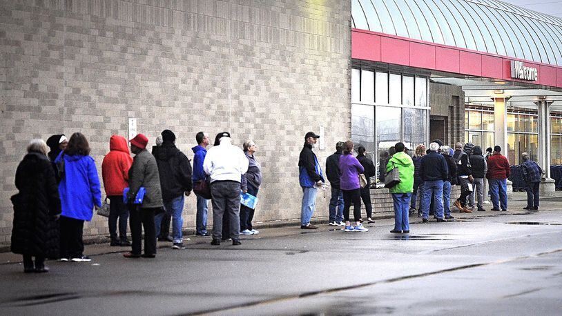 People wait outside Meijer in Springfield Monday morning. MARSHALL GORBY/STAFF