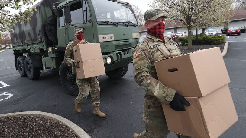 Ohio Army National Guardsmen, Sgt Kyle Smith, left, and Spc Logan Wilson deliver boxes of food to elderly residents in New Carlisle. BILL LACKEY/STAFF