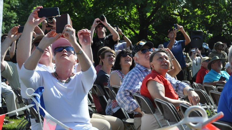 Spectators watch as two C-47 aircraft fly over Memorial Park at the National Museum of the U.S. Air Force on Thursday. The World War II era aircraft flew over the museum as part of a day of events to commemorate the 75th anniversary of D-Day.