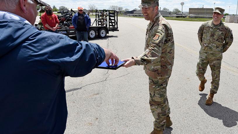 Air Force Col. Thomas P. Sherman, 88th Air Base Wing commander, awards 88th Civil Engineer Squadron Area B ground maintenance supervisor Bryan Spiller with an 88th ABW challenge coin at Wright-Patterson Air Force Base, May 1. U.S. Air Force photo by Ty Greenlees