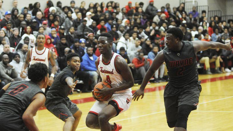 Trotwood’s Myles Belyeu is surrounded by Wayne’s Rashad McKee (left), Ronnie Hampton and Antwuan Johnson. Wayne defeated host Trotwood-Madison 90-87 in double-OT last month. Both teams will play in the upcoming 16th annual Premier Health Flyin’ to the Hoop. MARC PENDLETON / STAFF