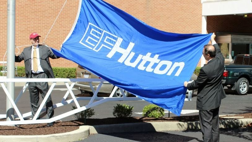 Chris Daniels and John Daniels of EF Hutton America raised its flag outside of its newly-renamed EF Hutton Tower at One Main Street on Sept. 2. The company is expected to bring 400 jobs to Springfield. MICHAEL COOPER/STAFF