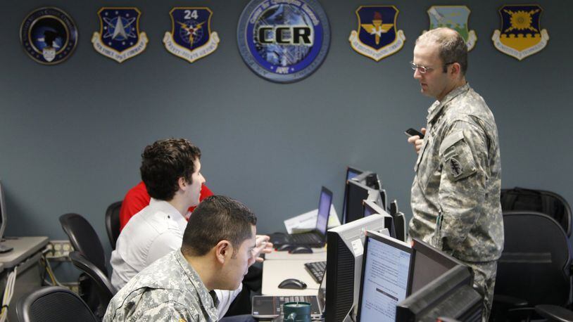 Center for Cyberspace Research graduate students talk before a 2013 cyber exercise at the Air Force Institute of Technology at Wright-Patterson Air Force Base. TY GREENLEES/STAFF