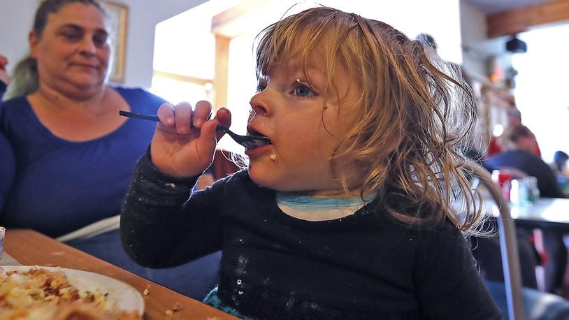 One year old Sophia Whitt was truly getting into her Italian Thanksgiving dinner, courtesy of Olive Garden, at the Springfield Soup Kitchen Thursday. Bill Lackey/Staff
