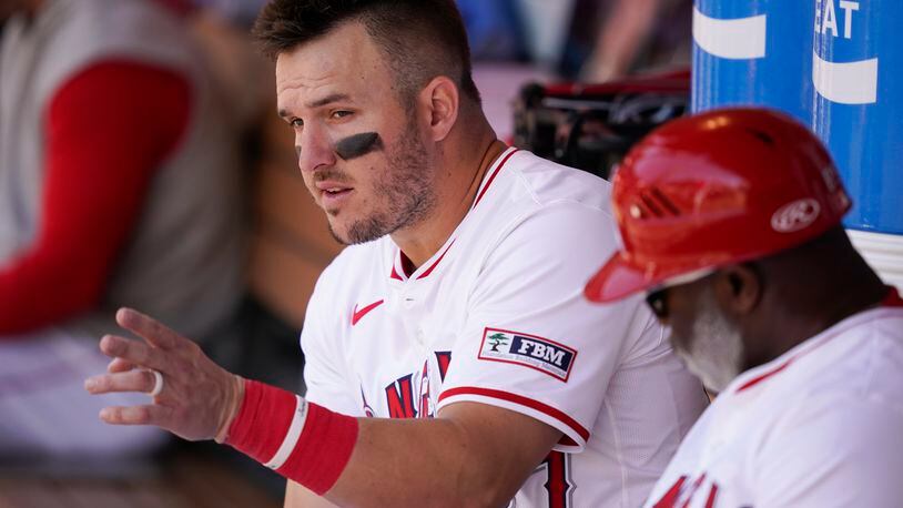 Los Angeles Angels designated hitter Mike Trout, left, speaks with third base coach Eric Young Sr. during the fifth inning of a baseball game against the Minnesota Twins, Sunday, April 28, 2024, in Anaheim, Calif. (AP Photo/Ryan Sun)