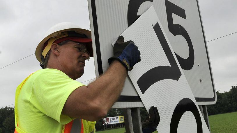 Dan Knoop, of the Ohio Department of Transportation, changes the speed limit signs along Interstate 70 in Clark County to 70 miles per hour Monday, July 1, 2013. Interstate 70 through Clark County is one of the areas in the state that has increased the speed limit from 65 to 70 mph effective July 1. Bill Lackey/Staff