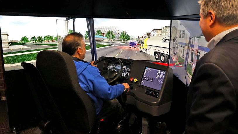 William Weekley, training manager of the Clark State College CDL program, demonstrates the different programs and scenarios that can be loaded into the new truck driving simulator Tuesday, Feb. 21, 2023 during an open house. BILL LACKEY/STAFF