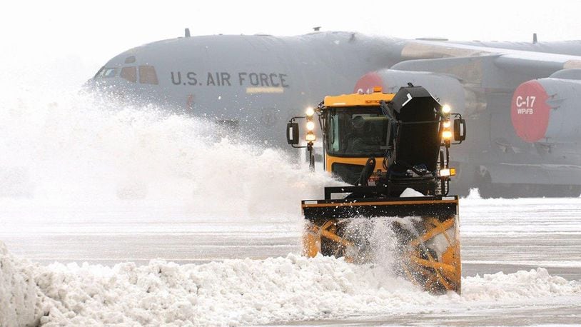 Snow surrounding a 445th Airlift Wing C-17 Globemaster III sitting on the ramp is removed as temperatures drop and fog rolls in during a 2014 winter storm at Wright Patterson Air Force Base.  (U.S. Air Force photo/Tech. Sgt. Frank Oliver)