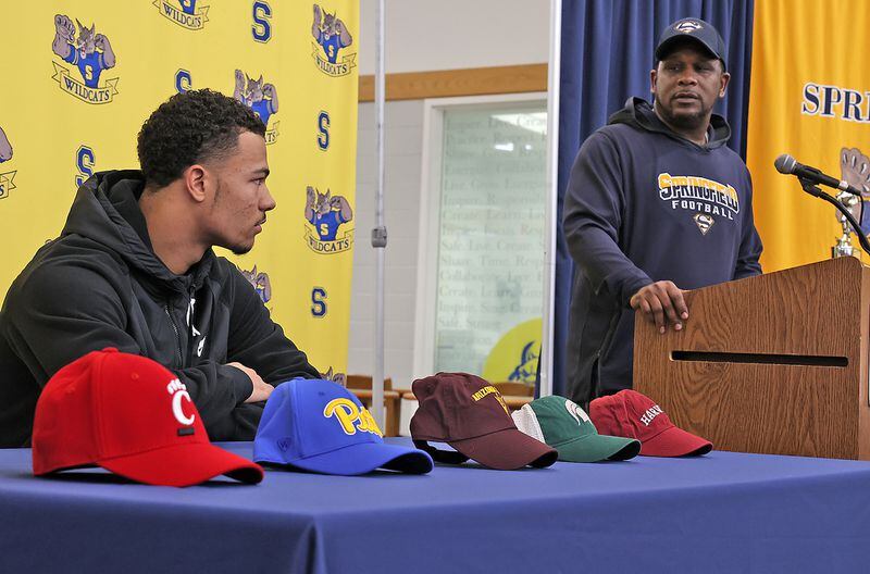 Maurice Douglass, the Springfield High School football coach,  talks about football standout Delian Bradley Wednesday before he picked a college during Signing Ceremony. BILL LACKEY/STAFF