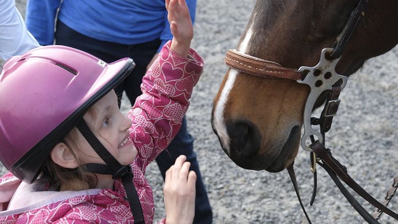 Kileigh Palmer, a student at Possum Elementary, gives her horse a pet after dismounting at the Yellow Springs Riding Center Thursday. Bill Lackey/Staff