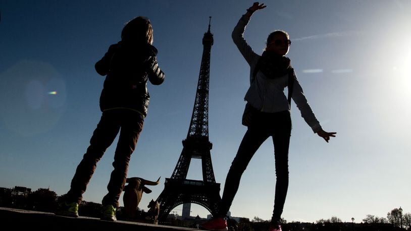 People pose for a picture at Trocadero with the Eiffel Tower on the background on November 15, 2015 in Paris, France. As France observes three days of national mourning members of the public continue to pay tribute to the victims of Friday's deadly attacks. (Photo by David Ramos/Getty Images)