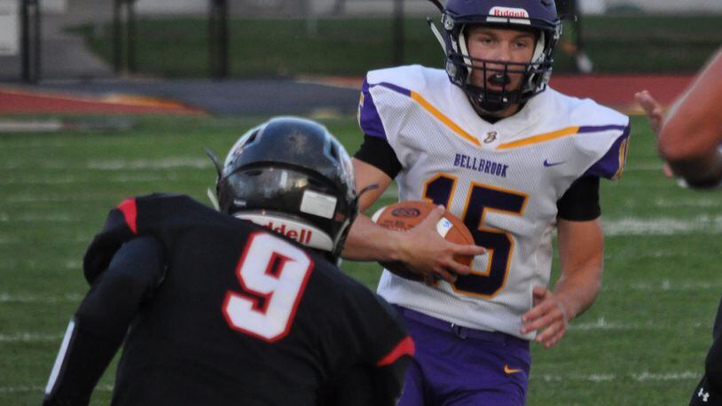 Bellbrook junior quarterback Brendan Labensky looks downfield while Tecumseh’s Blais Hale waits to deliver a hit Thursday Sept. 7, 2017, at Spitzer Stadium Sept. 7, 2017. Nick Dudukovich/Contributed