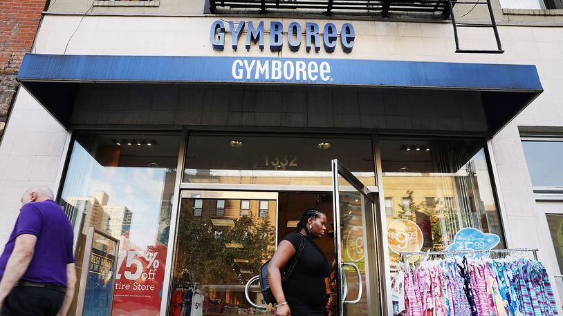 People walk by the children's clothing retailer Gymboree, which will reportedly file for bankruptcy protection.