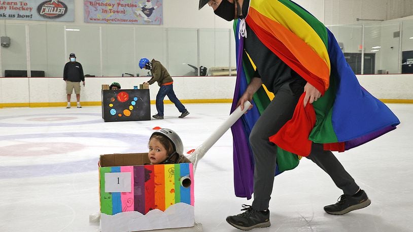 Jack Driscoll, 2, looks a little nervous as her father, Jeff, pushes her in a brightly colored cardboard bobsled Saturday during one of the races at The Chiller Ice Rink. BILL LACKEY/STAFF