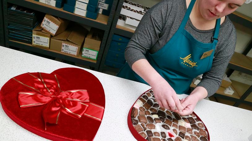 Melinda Bailey, an employee of Marie’s Candies, fills a three pound, heart shaped box of chocolates in 2017. Valentine’s Day is the second busiest time of the year for the West Liberty company as they make all their candy by hand. Their first busiest holiday is Christmas. BILL LACKEY/STAFF