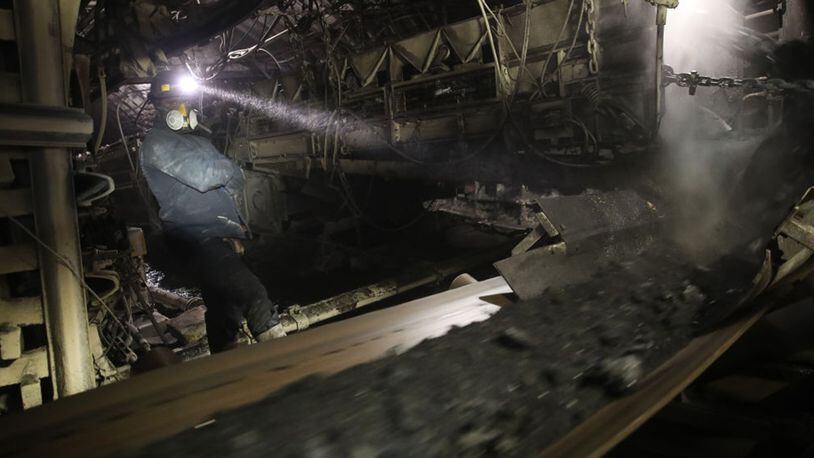 A coal miner monitors a juncture between conveyor belts moving coal more than 3,000 feet below the surface at the KWK Pniowek coal mine on November 30, 2018 in Pawlowice, Poland.