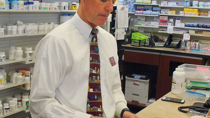 Pharmacist Eric Juergens of Madison Avenue Pharmacy counts opioid pills as he fills a prescription in Springfield on Tuesday morning. JEFF GUERINI/STAFF