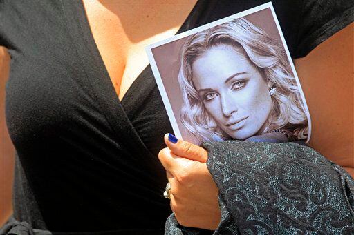A woman holds a photo of Reeva Steenkamp after Steenkamp's funeral in South Africa. Olympian Oscar Pistorius is charged with her murder but he says it was an accident.