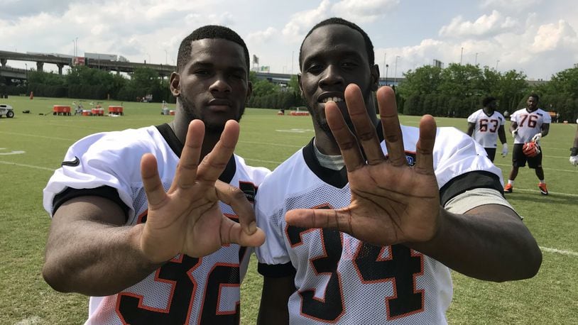 New Cincinnati Bengals teammates Mark Walton (left) and Quinton Flowers flash the 305 area code from their hometown of Miami during last week’s rookie camp at Paul Brown Stadium.