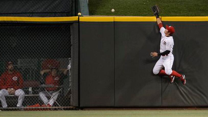 Cincinnati Reds centerfielder Shin-Soo Choo, right, leaps for and misses a home run ball off the bat of St. Louis Cardinals' Carlos Beltran in the fourth inning of a baseball game, Sunday, June 9, 2013, in Cincinnati. (AP Photo/Michael E. Keating)