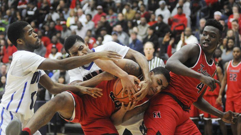 Trotwood’s Torrey Patton (with ball) and temmate Myles Belyeu (right) draw Dunbar defenders Sh’Mari Jamison (left) and Devon Baker. Trotwood-Madison defeated Dunbar 83-54 in a boys high school basketball D-II regional final at Fairmont’s Trent Arena on Saturday, March 18, 2017. MARC PENDLETON / STAFF