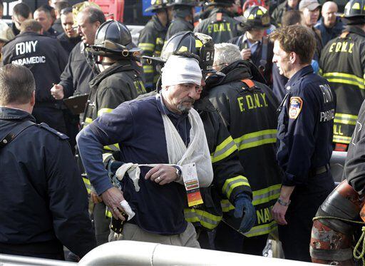 An injured passenger of the Seastreak Wall Street ferry is aided by New York City firefighters, in New York.