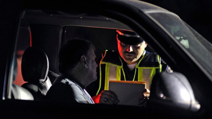 Monroe police officer Doug Leist works at an OVI checkpoint Early Saturday morning, June 11, 2011 along OH-4.