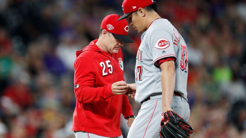 Cincinnati Reds manager David Bell, left, takes the ball from relief pitcher David Hernandez, who had given up a double to Colorado Rockies’ Ian Desmond during the eighth inning of a baseball game Friday, July 12, 2019, in Denver. (AP Photo/David Zalubowski)
