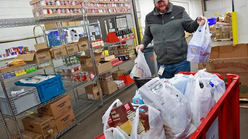 Elliott Martin stocks the food pantry at the Second Harvest Food Bank in this Dec. 5, 2022, file photo. BILL LACKEY/STAFF