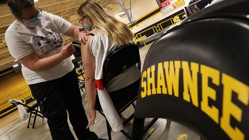Nicole Wilson, a nurse at the Clark County Combined Health District, gives a student his COVID vaccine injection during a vaccine clinic at Shawnee High School. BILL LACKEY/STAFF