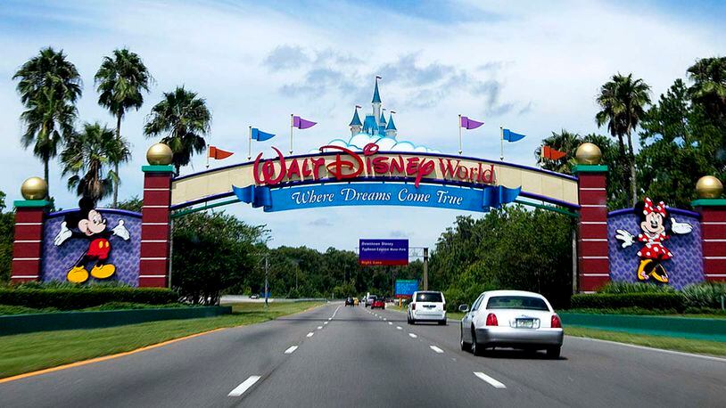 Vehicles pass the entrance to the Walt Disney World theme park and resort in Lake Buena Vista, Florida. Disney is paying college tuition for thousands of Florida-based workers and just added the University of Central Florida to its Aspire program.