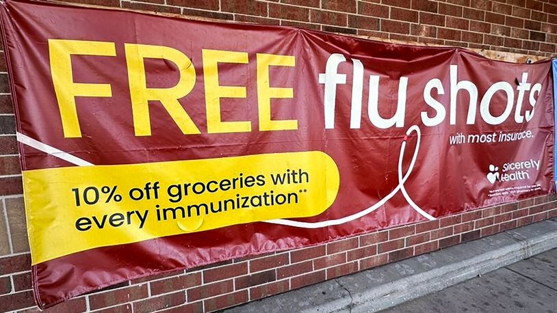 FILE - A sign for flu vaccination is displayed outside of a grocery store in Glenview, Ill., Thursday, Feb. 15, 2024. On Friday, April 26, 2024, the Centers for Disease Control and Prevention said last week, for the third straight week, medical visits for flu-like illnesses dipped below the threshold for what's counted as an active flu season. (AP Photo/Nam Y. Huh)