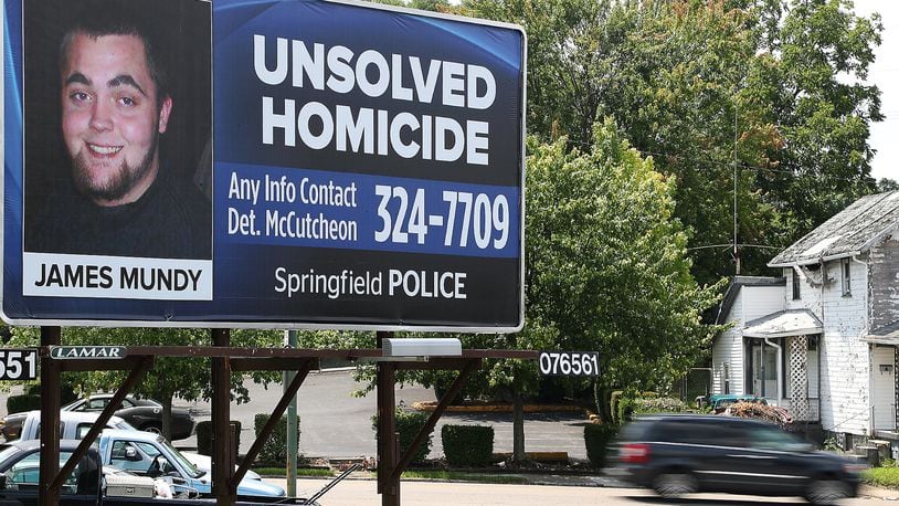 Cars drive past a billboard along East Main Street, placed by the Springfield Police Division, asking for help solving an unsolved homicide case. BILL LACKEY/STAFF