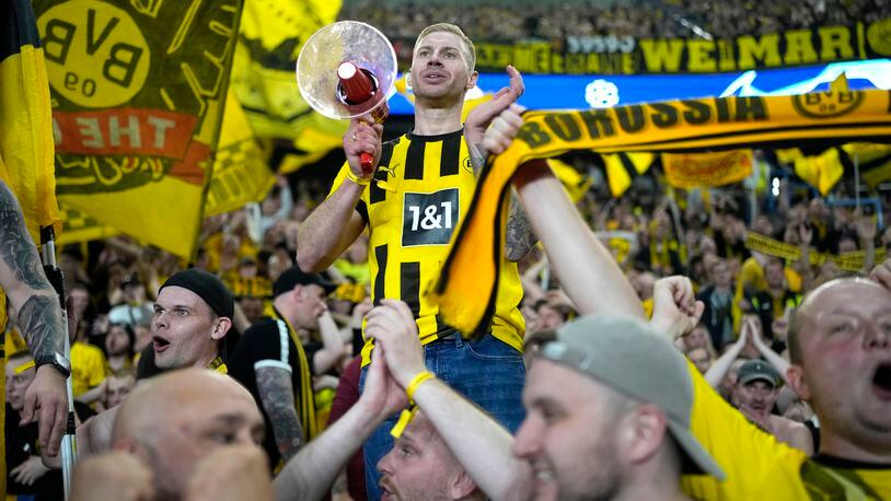 Borussia Dortmund supporters celebrate at the end of the Champions League semifinal second leg soccer match between Paris Saint-Germain and Borussia Dortmund at the Parc des Princes stadium in Paris, France, Tuesday, May 7, 2024. (AP Photo/Lewis Joly)