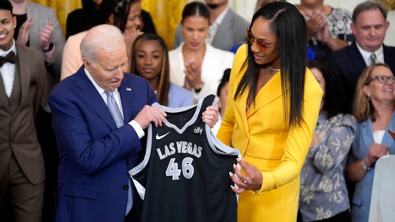 A'ja Wilson, of the WNBA's Las Vegas Aces, right, presents a jersey to President Joe Biden during an event to celebrate the 2023 WNBA championship team, in the East Room of the White House, Thursday, May 9, 2024, in Washington. (AP Photo/Evan Vucci)