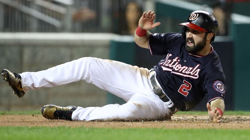 The Nationals' Adam Eaton celebrates as he slides home to score on an RBI double hit by teammate Anthony Rendon in the third inning of game three of the National League Championship Series against the St. Louis Cardinals at Nationals Park on October 14, 2019 in Washington, DC. (Photo by Rob Carr/Getty Images)
