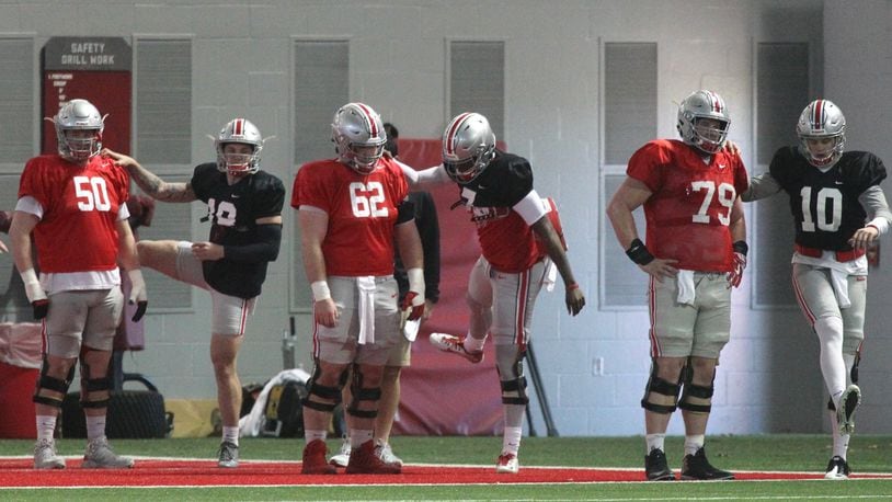 Ohio State offensive linemen and quarterbacks, including Dwayne Haskins, center in black, stretch before practice on Monday, March 26, 2018, at the Woody Hayes Athletic Center in Columbus. David Jablonski/Staff