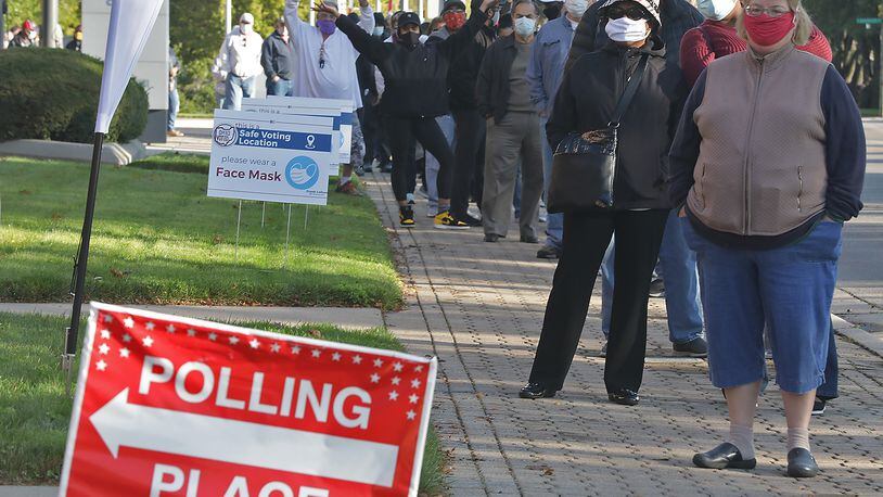 Clark County residents wait in line outside Clark State's Turner Studio Theater to vote early Tuesday. BILL LACKEY/STAFF