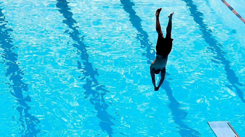 A diver hangs over the water just before breaking the surface Friday, June 2, 2023 at Splash Zone Aquatic Center in Springfield. BILL LACKEY/STAFF