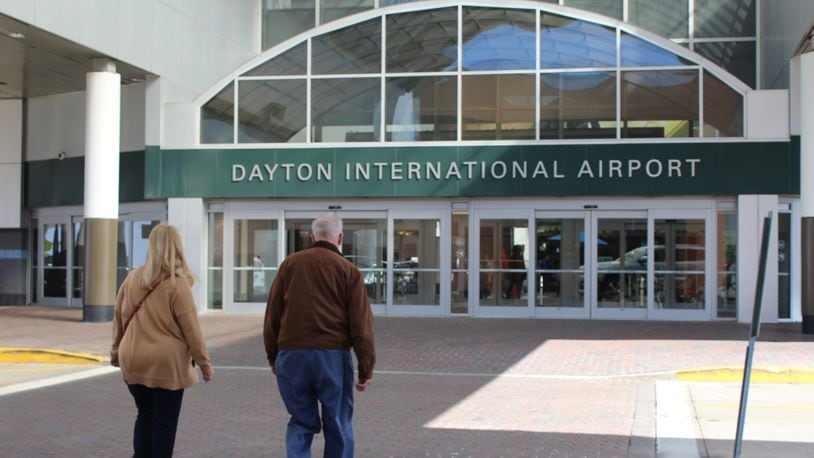 Travelers walk in front of the Dayton International Airport. CORY FROLIK/STAFF