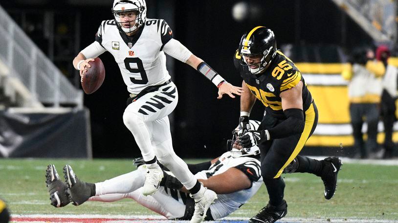 Cincinnati Bengals quarterback Joe Burrow (9) eludes Pittsburgh Steelers defensive tackle Chris Wormley (95) during the second half of an NFL football game, Sunday, Nov. 20, 2022, in Pittsburgh. (AP Photo/Don Wright)