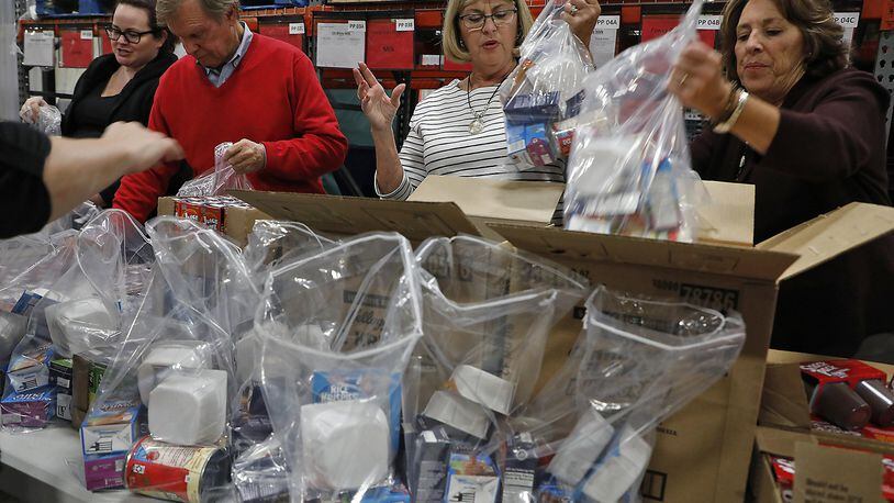 Members of the Springfield Rotary Club packaged hundreds of Power Pack food bags for Fulton Elementary Wednesday at the Second Harvest Food Bank. Bill Lackey/Staff
