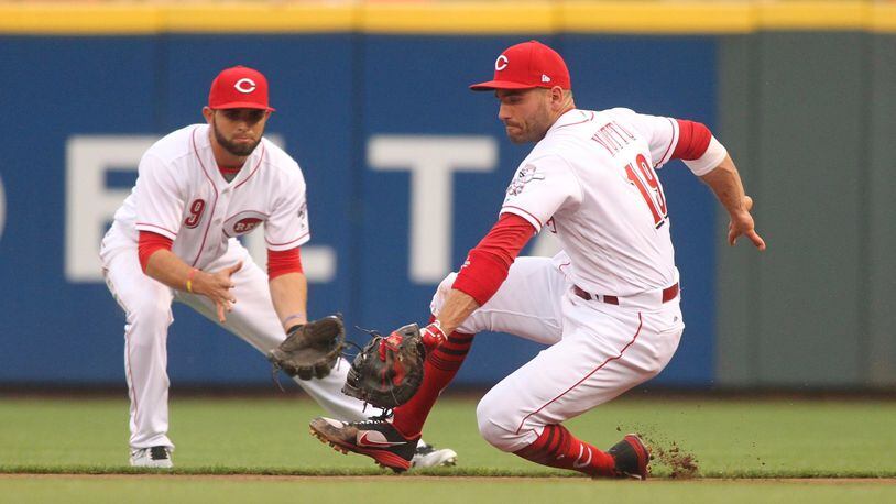 Reds first baseman Joey Votto fields a ball in front of second baseman Jose Peraza against the Brewers on Friday, April 14, 2017, at Great American Ball Park in Cincinnati. David Jablonski/Staff